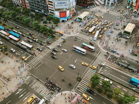 Aerial view showcasing busy city street life with traffic and pedestrians at an intersection.